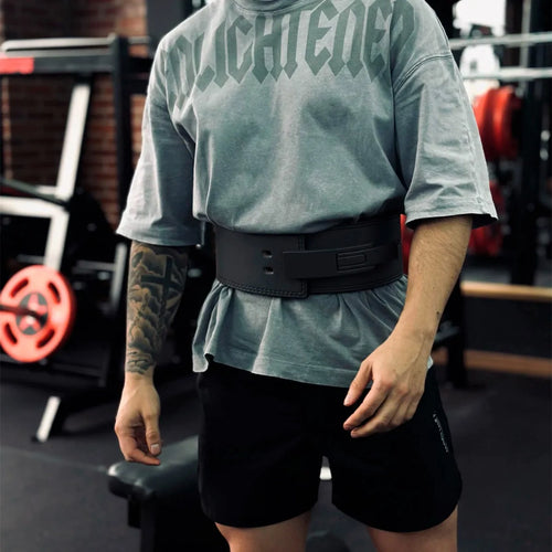 Atleta con remera gris oversize usando el Cinturón Forge en el gimnasio